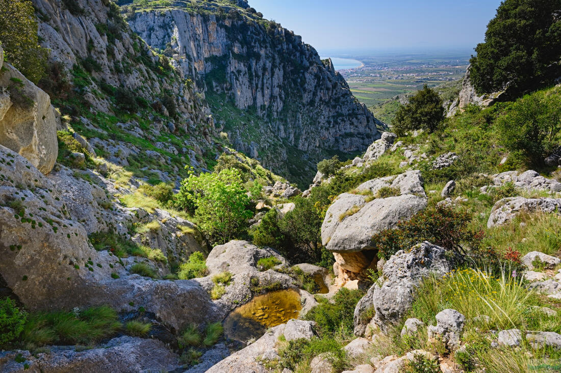 Sziklás terep a Gargano Nemzeti Parkban, a háttérben a Manfredonia-öbölben